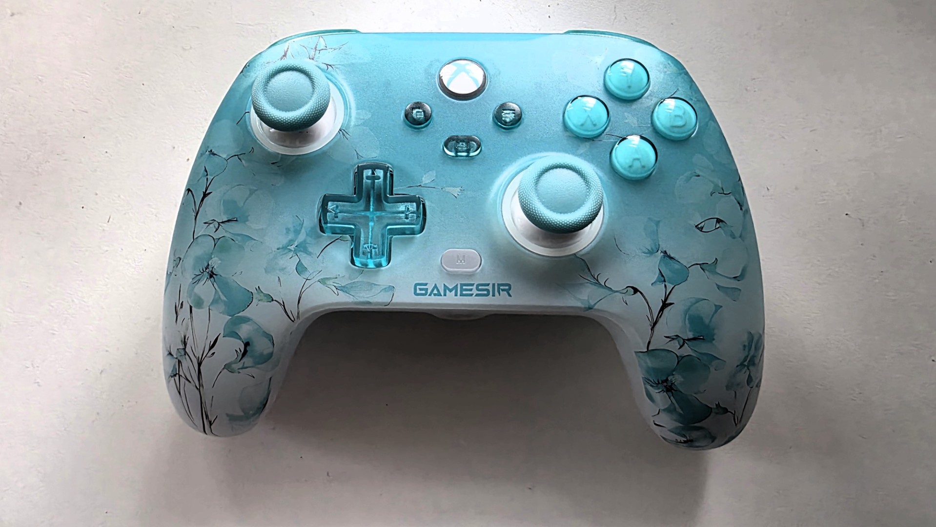 A blue and white controller with floral pattern