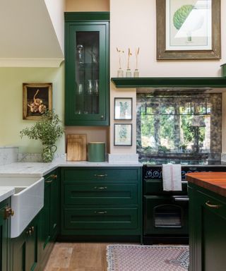 kitchen with dark green cabinets, light pink walls