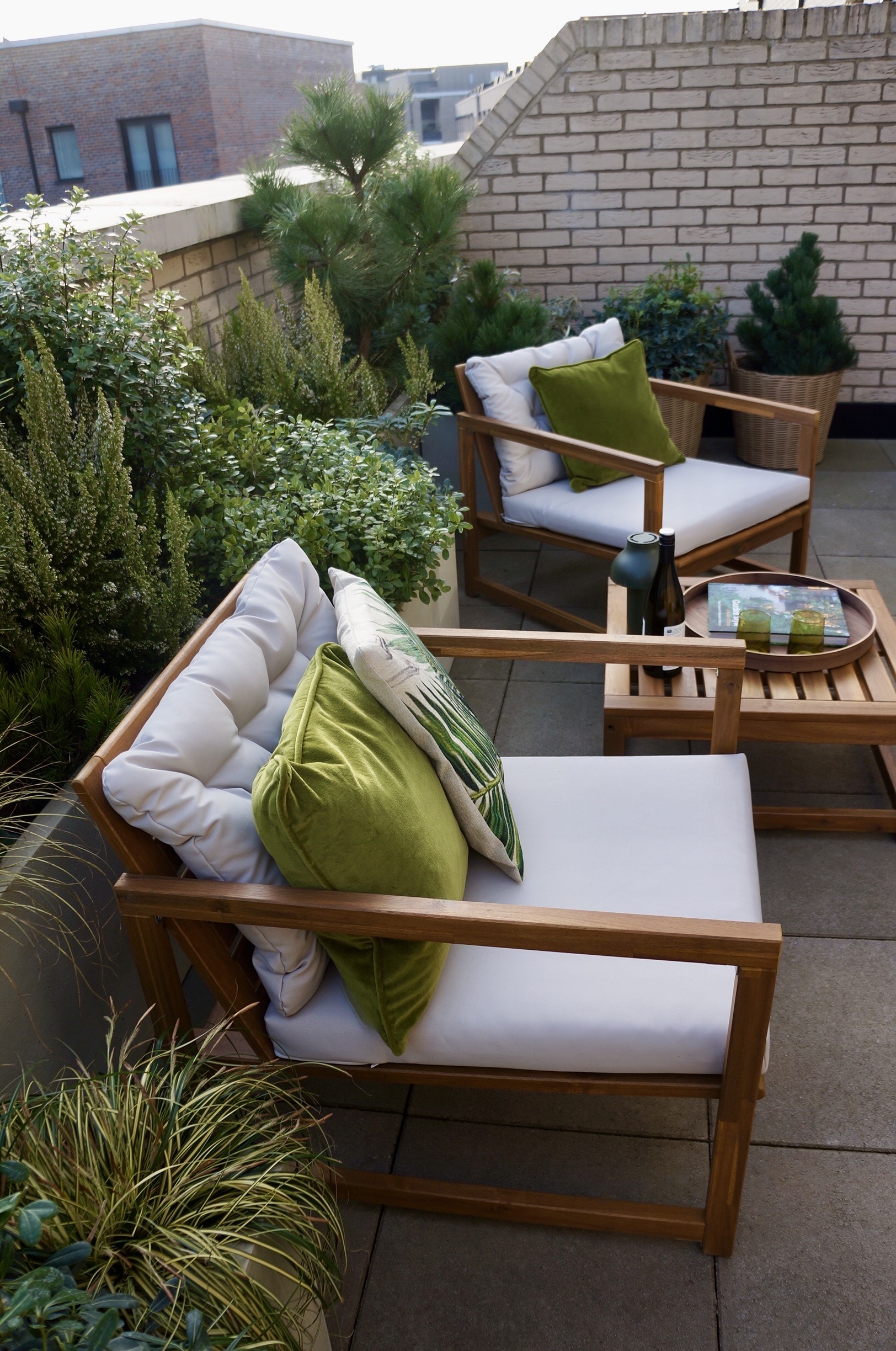 rooftop garden with lounge seating and potted plants lining the walls