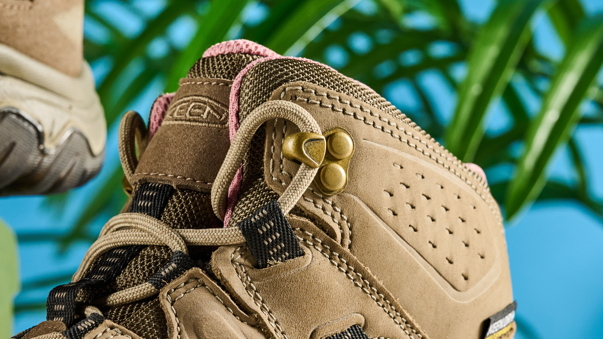 Keen Targhee IV hiking boots photographed in front of a blue background.