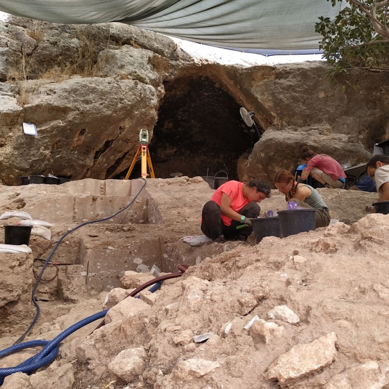 A group of archaeologists excavate a rocky site