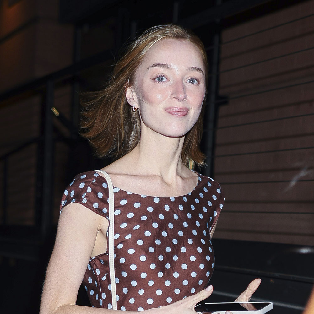 Phoebe Dynevor wearing a brown polka dot dress with black flip flops, and Louis Vuitton bag