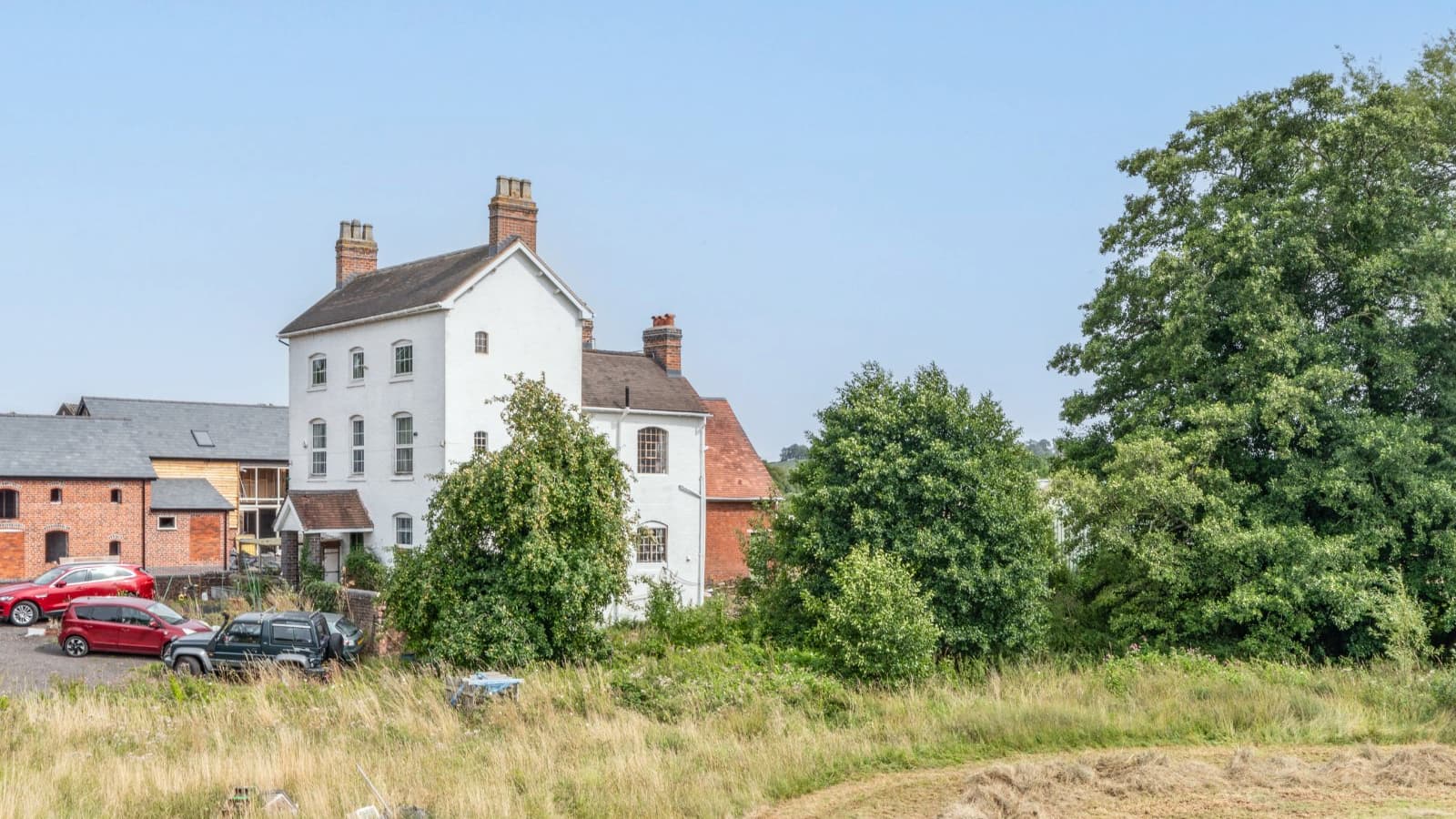 A three-storey farmhouse with white painted exterior