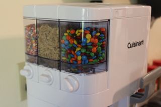 A close up of the topping dispensers on the Cuisinart Mix It In ICE-48 Ice Cream Maker