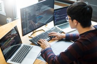 Software engineer examining code from a software