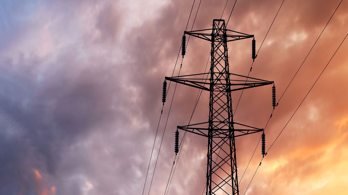 Detail of a British Style Electricity Pylon and suspended electic cables against a Blue Cloudy Sky