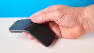 Logitech Mobi Fold mouse in graphite photographed in front of a blue background