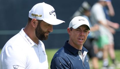 Jon Rahm and Rory McIlroy walk down the fairway