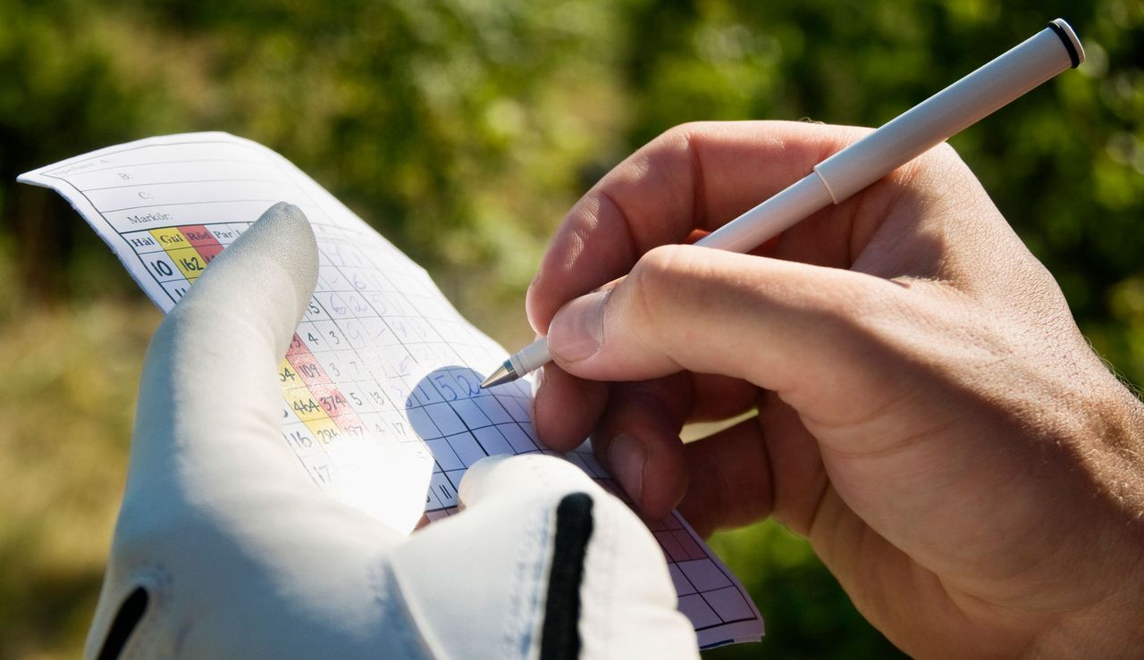 A golfer signs a scorecard