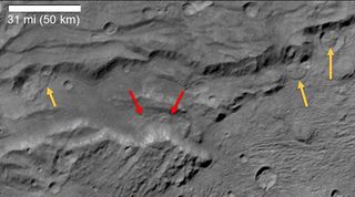 Red and yellow arrows indicate the presence of landslides in Serenity Chasma on Pluto's largest moon, Charon.