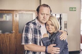 Martin (Michael Jibson) puts his arms around wife Kathy (Sheridan Smith) in the police station, both with looks of anxiety on their face as they learn about the charges Noah is facing