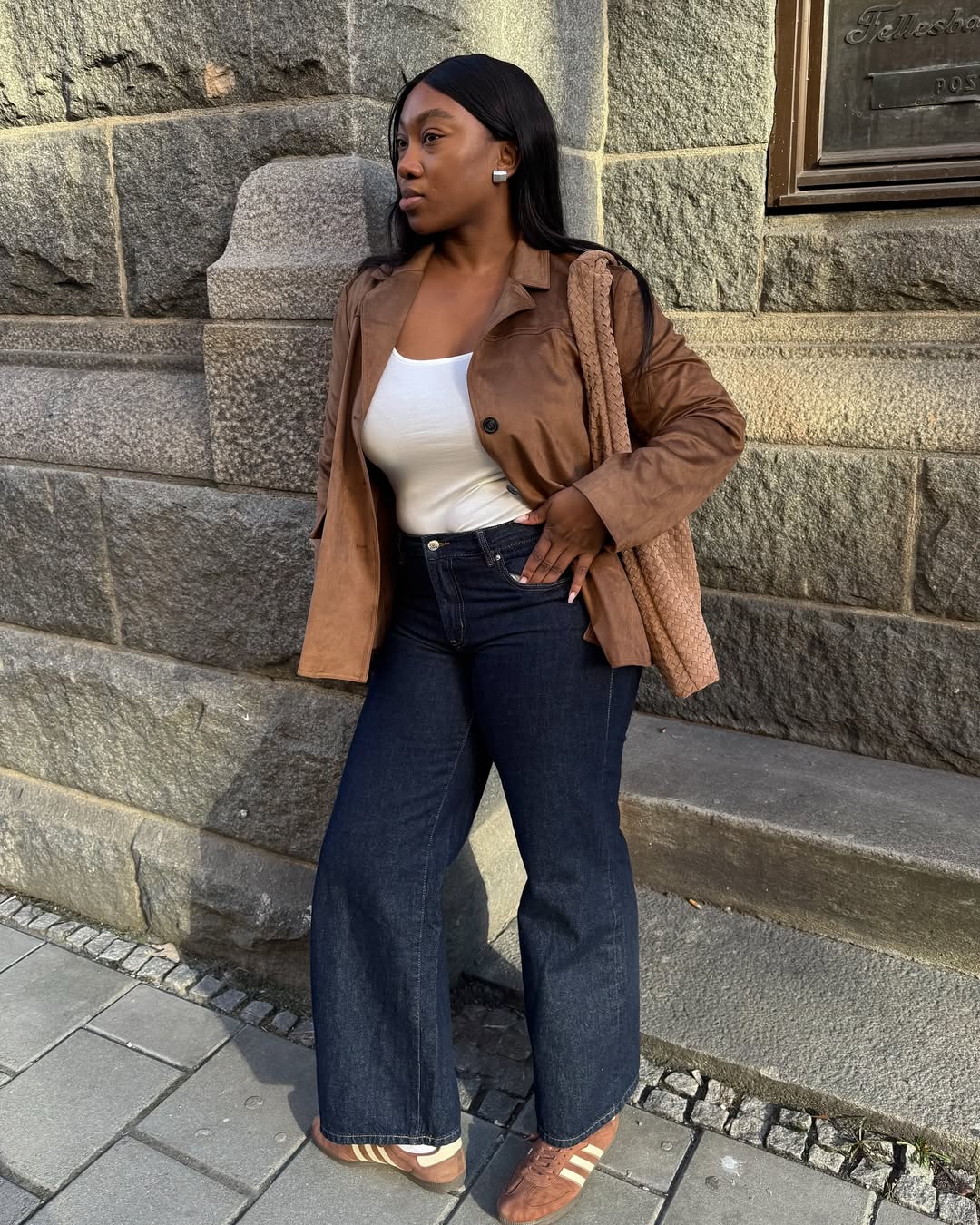 @nnennaechem wears a pair of wide-leg jeans, trainers and a lightweight jacket