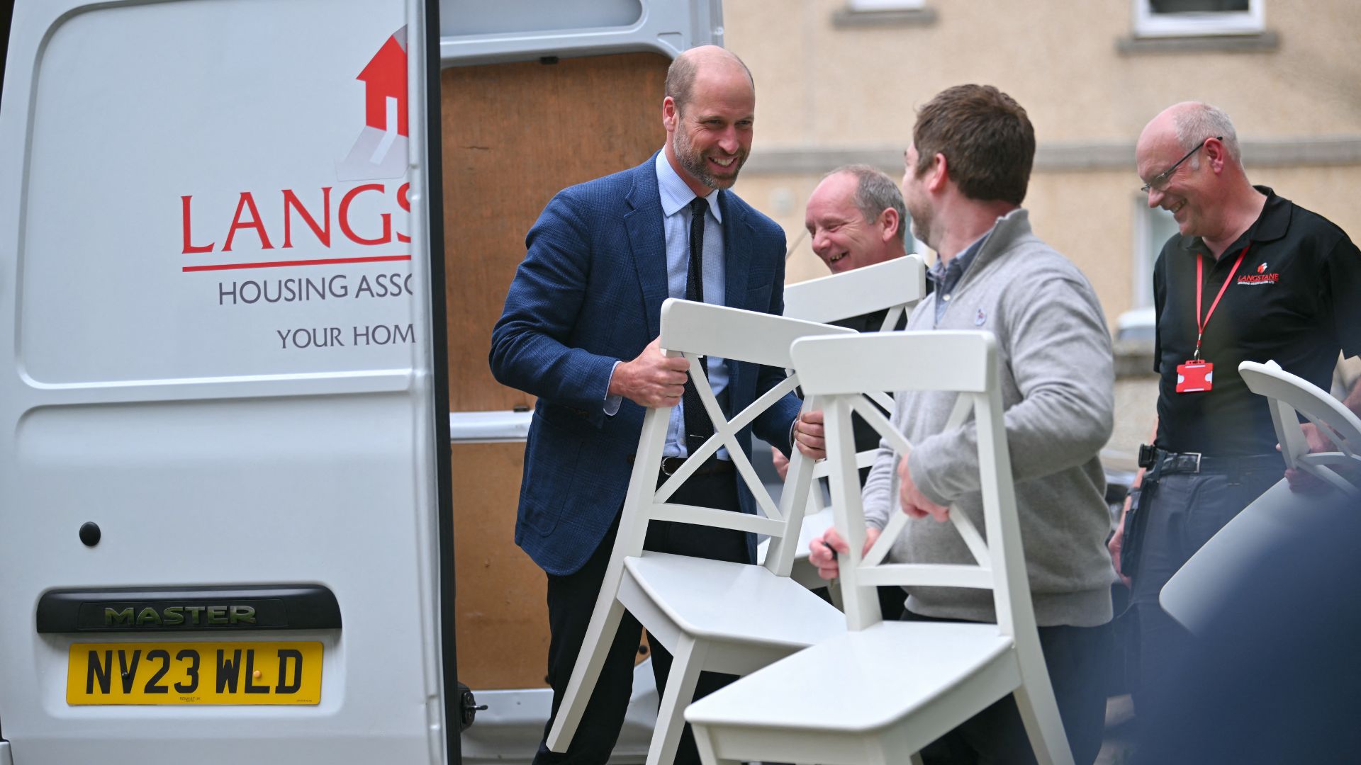 Prince William helps a new tenant move furniture into a new flat during a visit to Langstane Housing Association, in Aberdeen, Scotland, on June 30, 2026