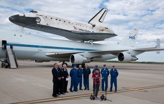 NASA Deputy Administrator Lori Garver, at podium, speaks to those in attendance at Apron W after the 747 Shuttle Carrier Aircraft (SCA) with space shuttle Discovery mounted on top rolled to a halt at Washington Dulles International Airport, Tuesday, April