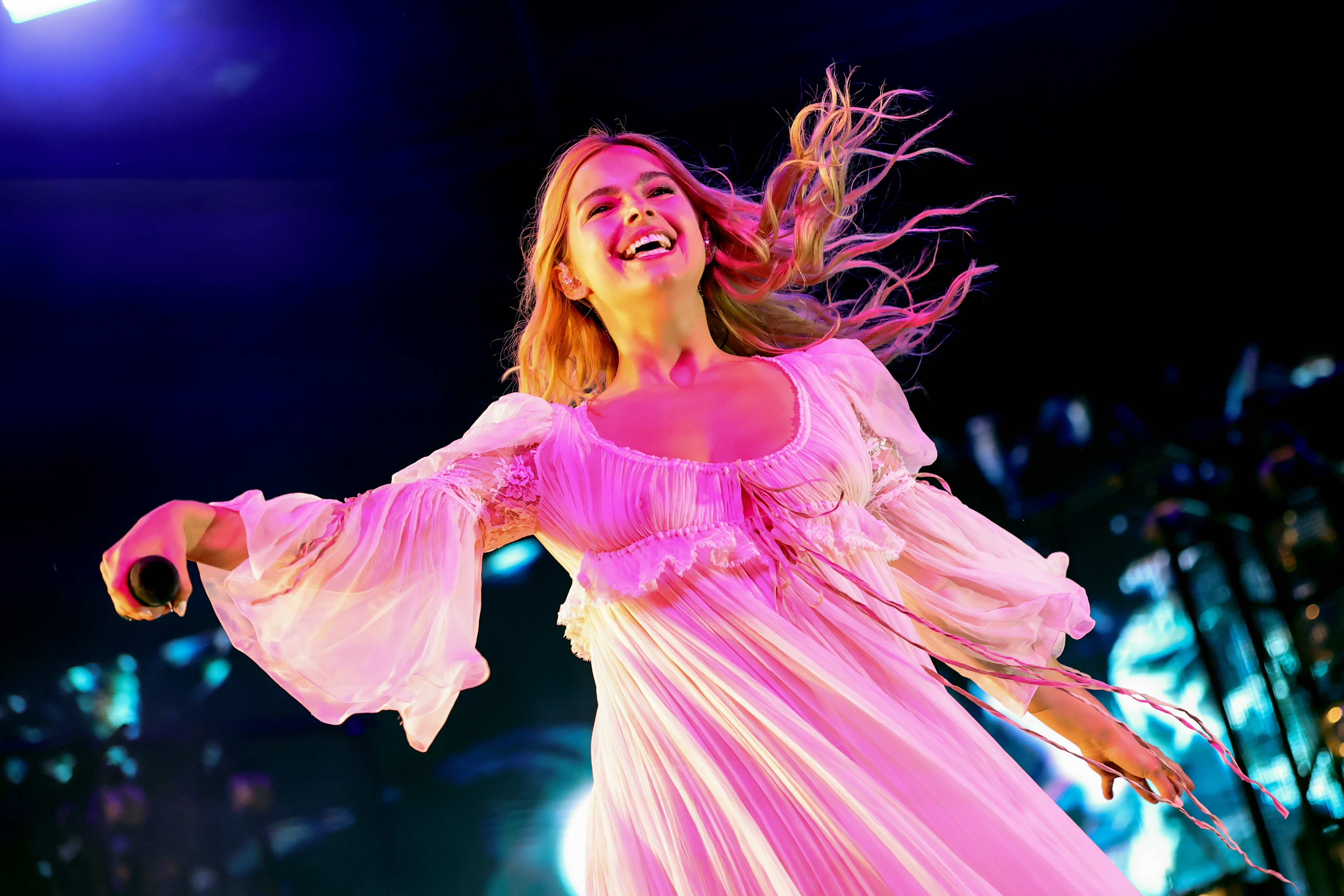 addison rae singing and wearing a long sleeve white sheer dress while on stage at coachella 2025