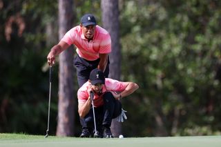 Charlie and Tiger Woods line up a putt