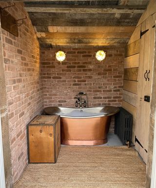 rustic bathroom with brick slip tiled walls, wood cladding, wooden door and ceiling