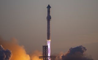 A giant rocket lifts off at sunrise with its fins and booster in silhouette