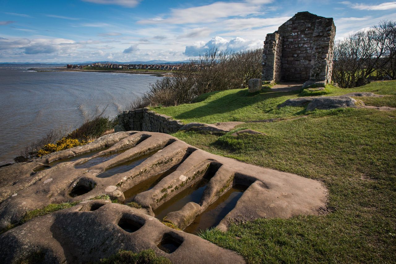 Unusual rock cut graves next to the ruins of St. Patrick&#039;s Chapel overlooking Morecambe Bay, Heysham.