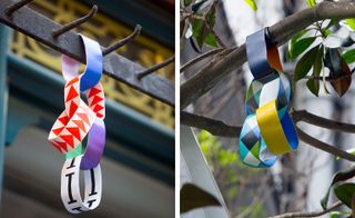 LEFT: Interlocked colourful paper wrist band hanging off a metal pole. RIGHT: Interlocked colourful paper wrist band hanging off a tree branch