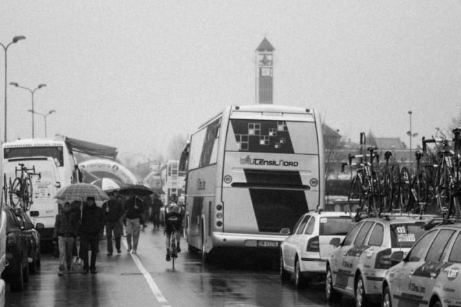Fans walk along the team cars and buses in Monticelli, Italy.