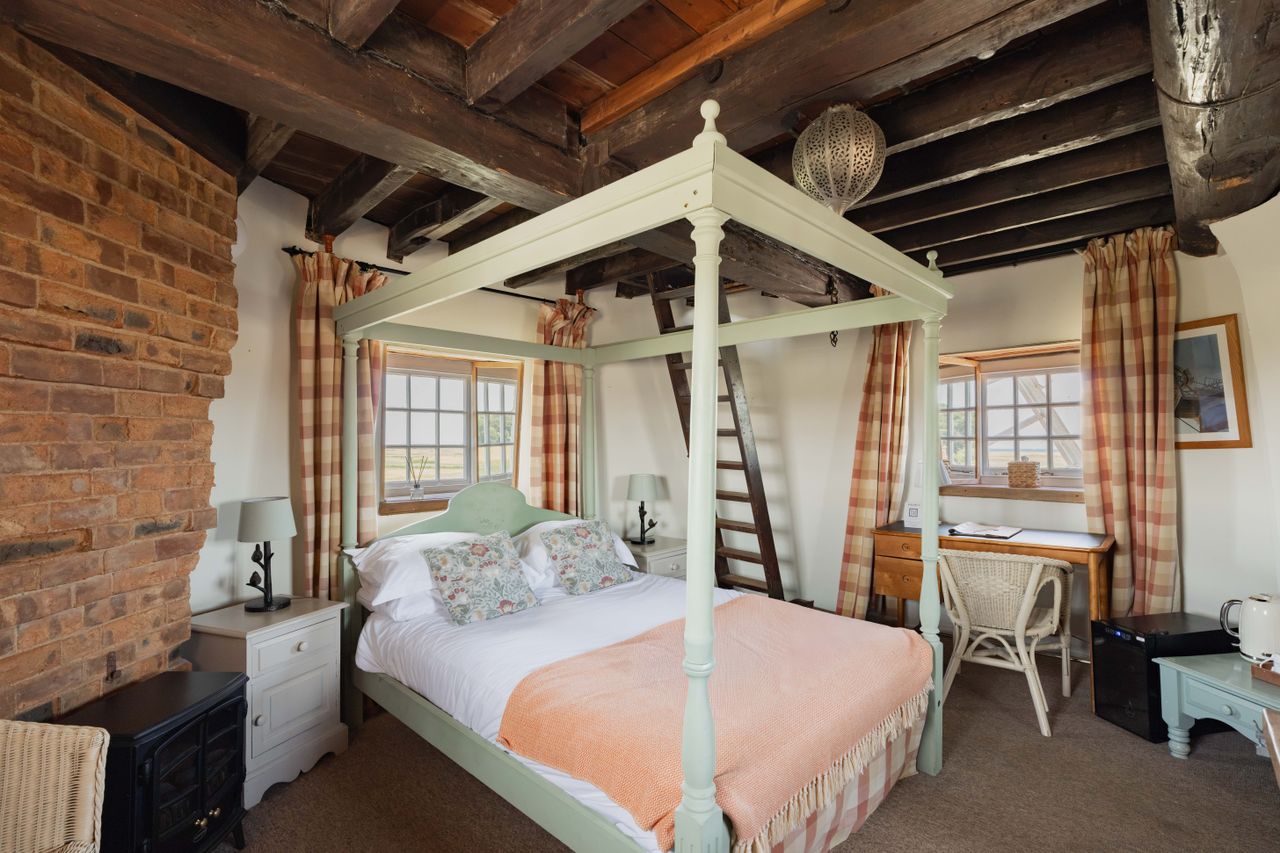 Cley Windmill. The mill is surrounded by reed beds and little rivers, and it is red brick with a white top. Inside, the rooms are luxurious but rustic, with lots of brick and exposed beams.