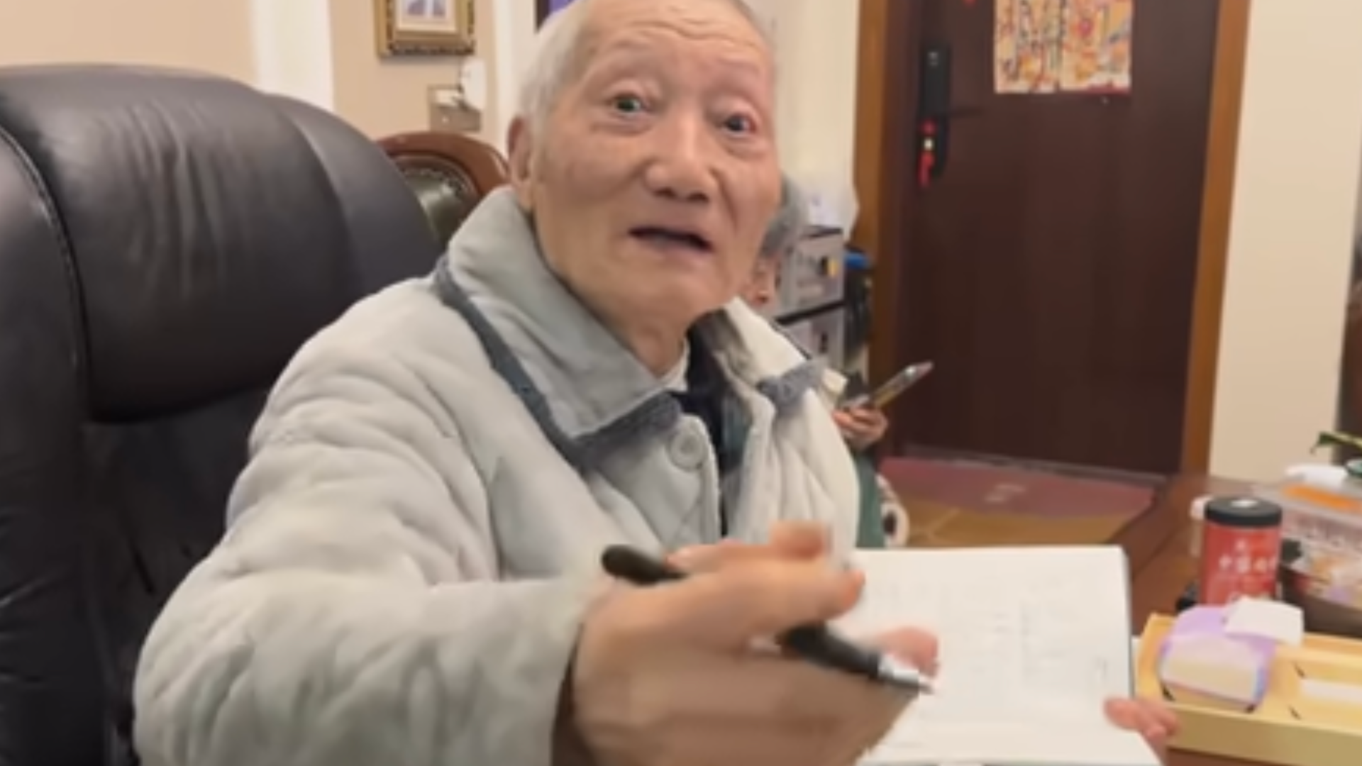 Yang Binglin holds a notebook and pen