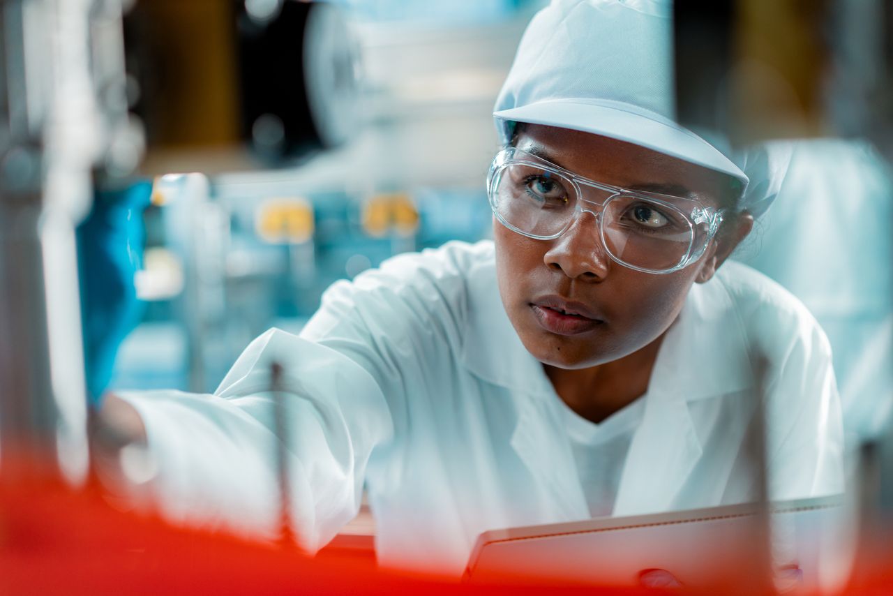 Female engineer in a drinking water factory in professional uniform.