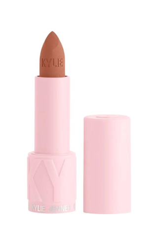 Kylie Cosmetics peach lipstick in front of a plain backdrop