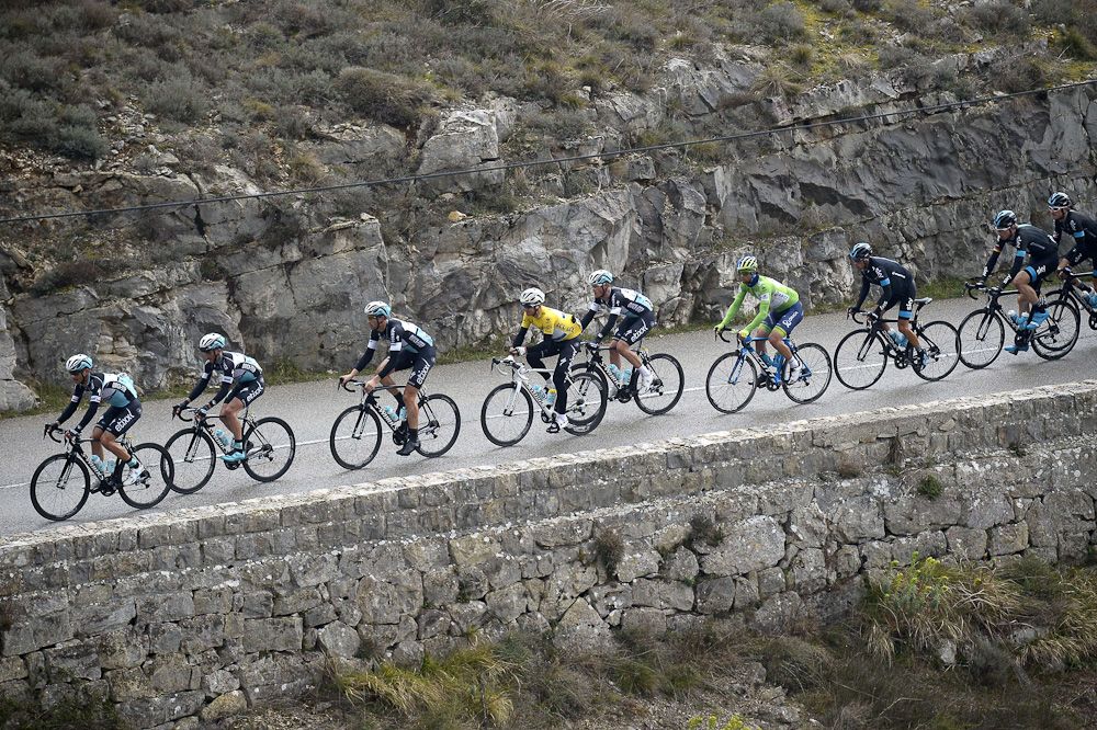 Michal Kwiatkowski, wearing the overall leader's yellow jersey, rides in the pack with his teammates of Etixx-Quick Step.