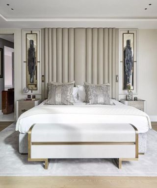 White bedroom with fluted floor to ceiling headboard and symmetrical bedside tables