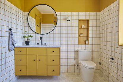 A yellow and white bathroom with yellow tile grout