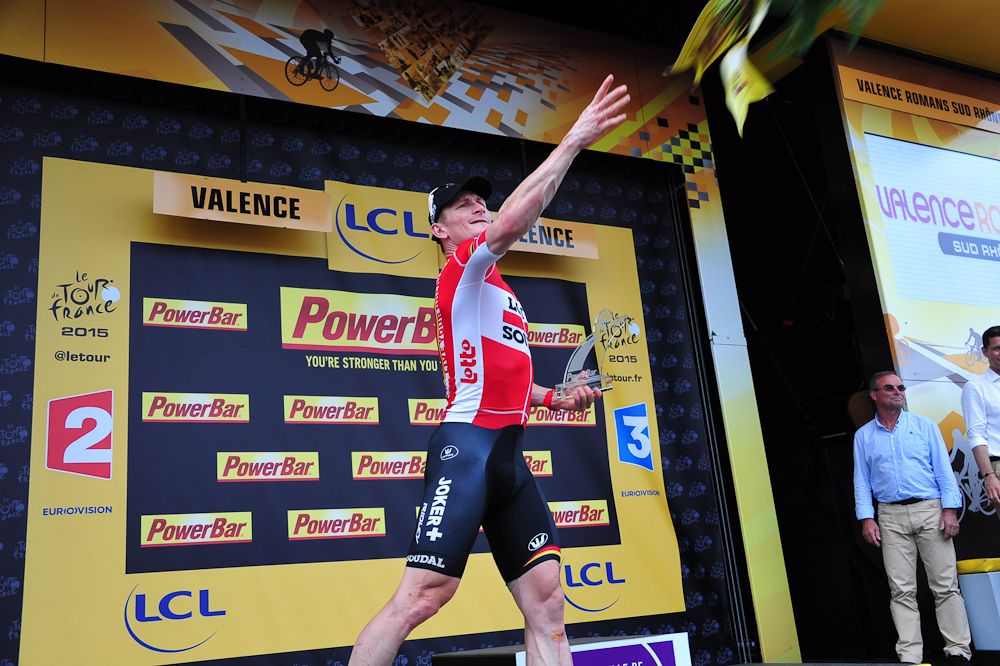 Andre Greipel tosses his bouquet on the stage 15 podium.