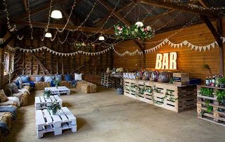 Party Barn decorated for social event, with bunting, string lights and illuminated bar sign