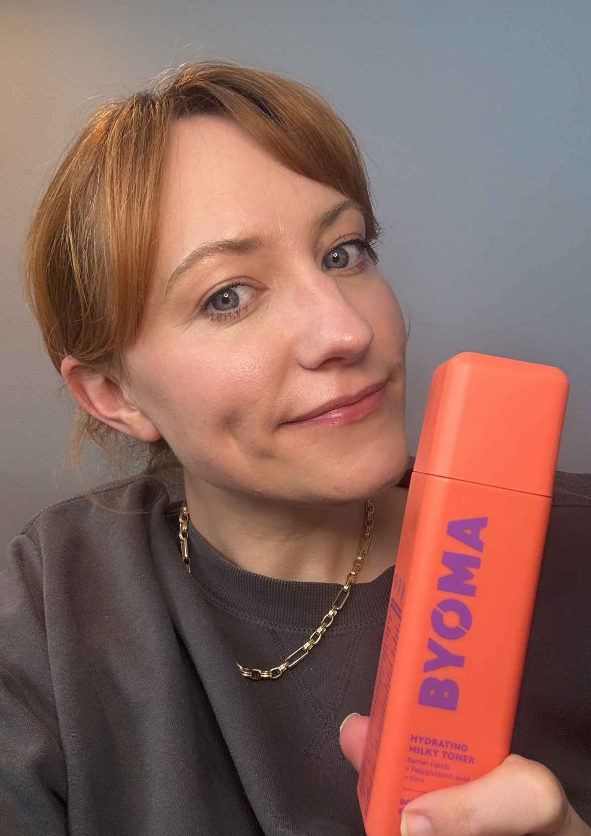 matilda holding a bottle of byoma milky toner