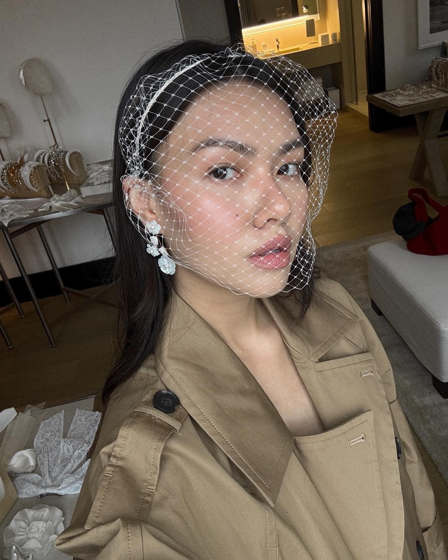 A woman with glowing skin wearing a bridal headpiece