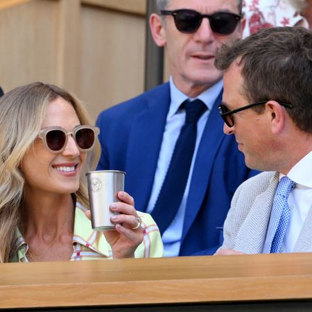 Harriet Sperling holding a cup and smiling at Peter Phillips at Wimbledon