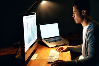 Can you use a laptop as a monitor? image shows man sitting at a computer