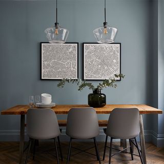 blue dining room with wooden dinning table and grey chairs and frame on wall
