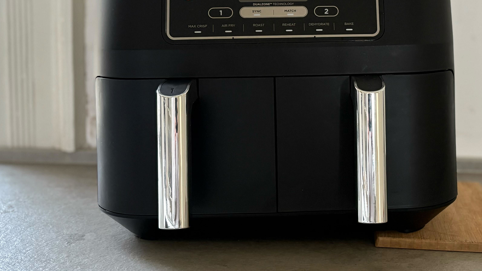 double drawer air fryer propped up on an uneven surface on kitchen counter