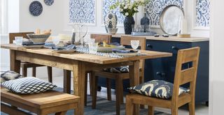 white and blue dining room with a teak wooden dining table with seats and bench seating