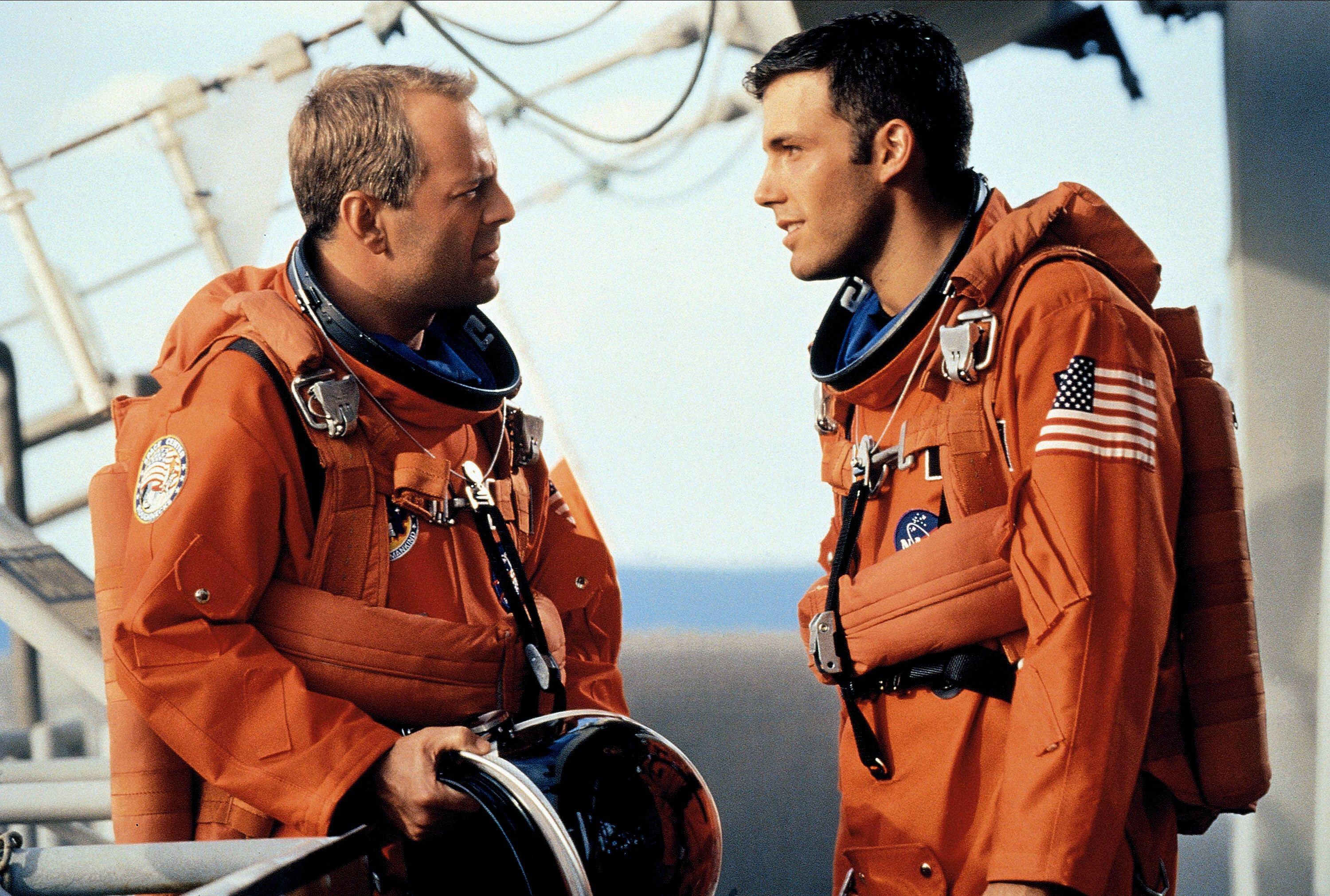 Bruce Willis and Ben Affleck in orange space suits on a space ship in 'Armageddon'
