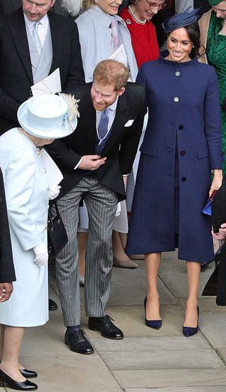 Queen Elizabeth II (L) talks with Britain's Prince Harry, Duke of Sussex, and Meghan, Duchess of Sussex after the wedding of Britain's Princess Eugenie of York to Jack Brooksbank at St George's Chapel, Windsor Castle, in Windsor, on October 12, 2018