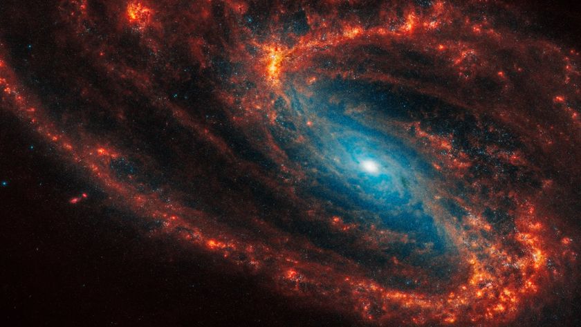 A photo of a spiral galaxy with orange arms and a glowing blue center