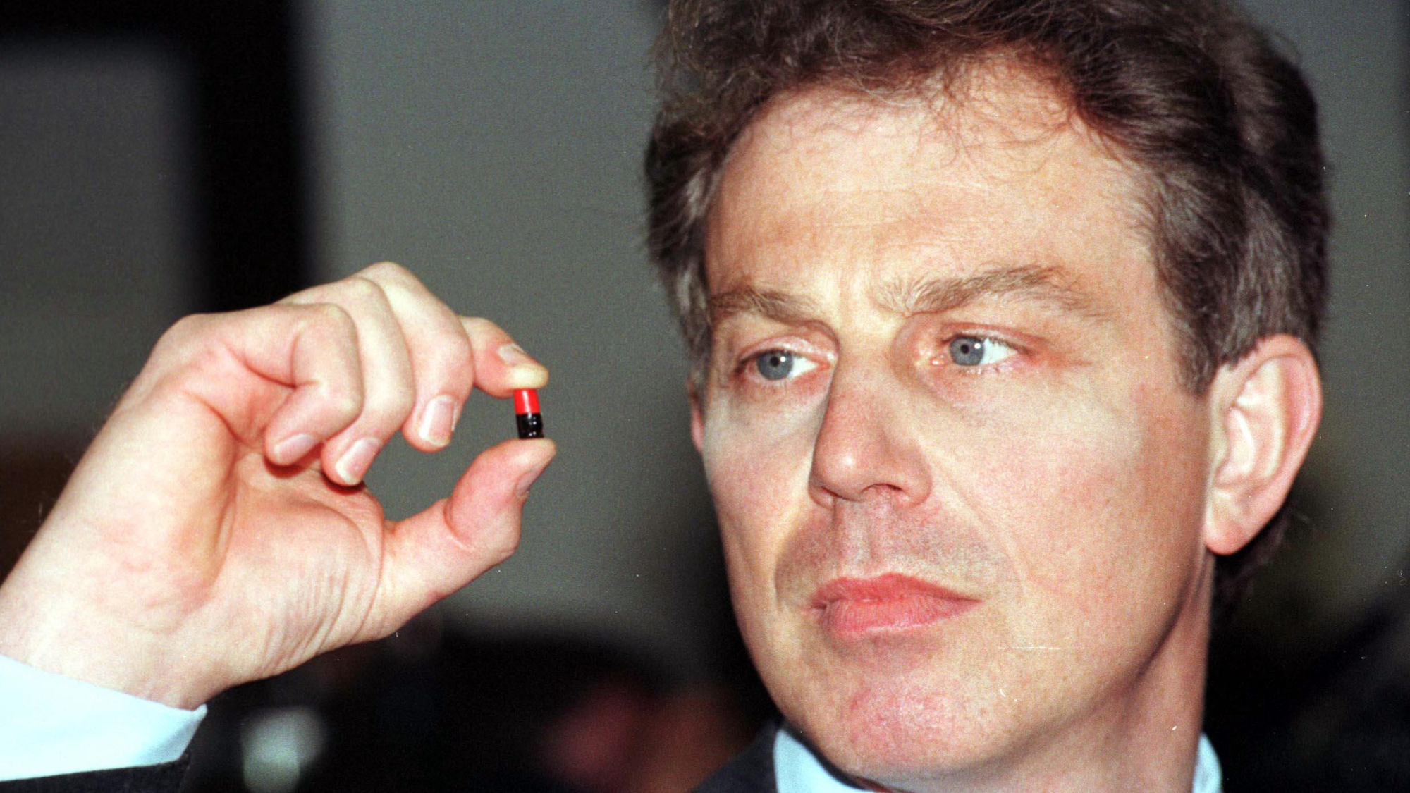 Tony Blair inspecting an ecstasy pill.