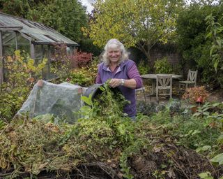 Horticulturalist Anne Swithinbank in front of a home compost pile