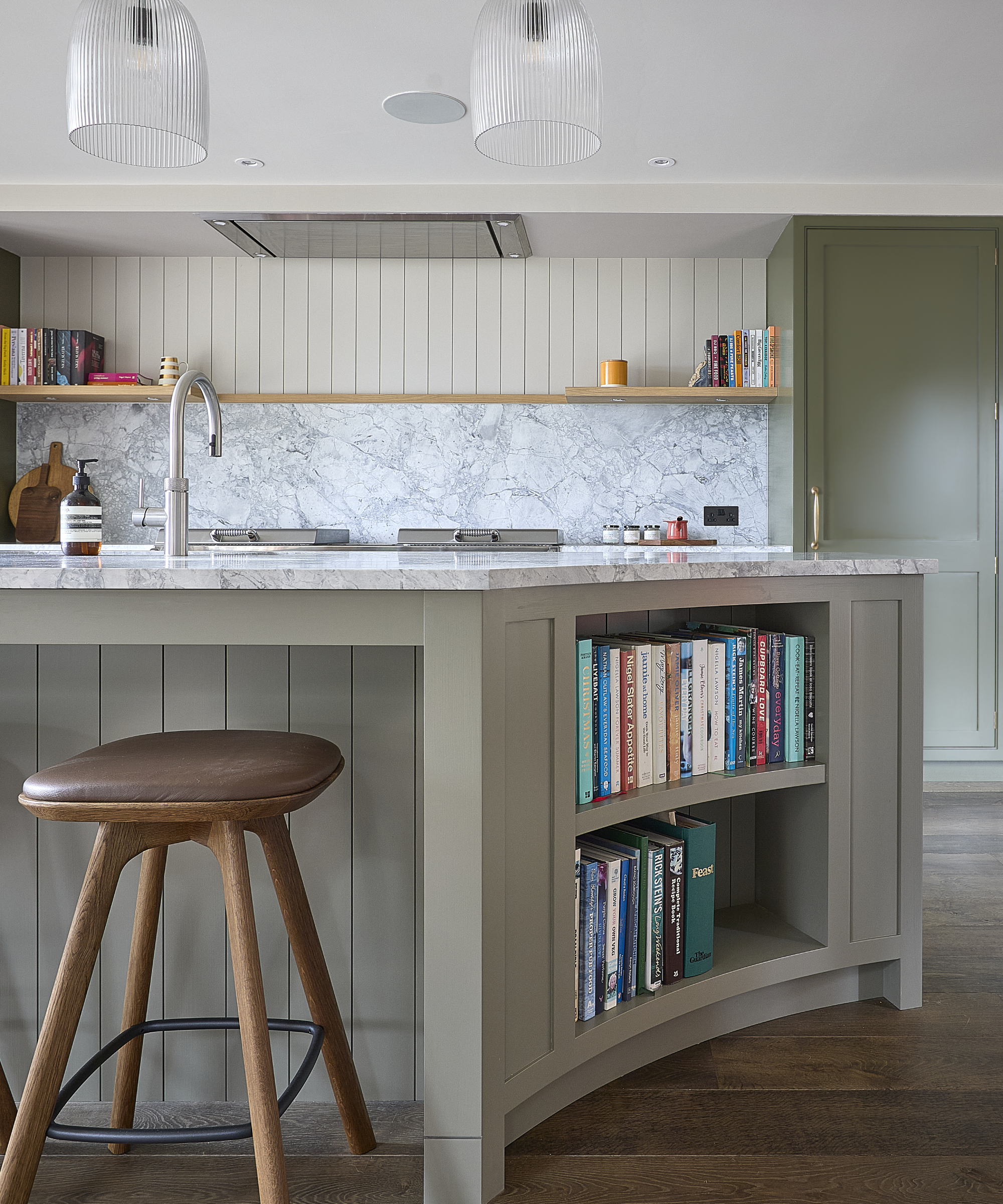 kitchen island with curved side section and built in bookcase section