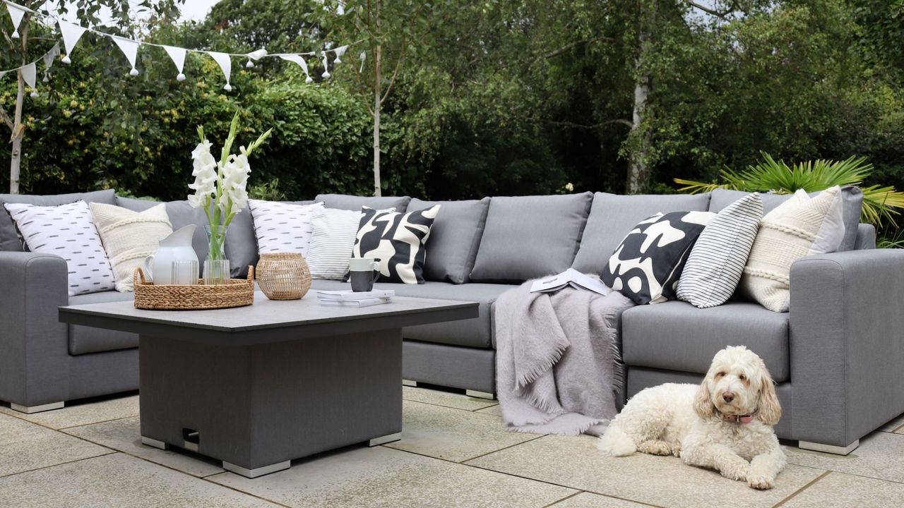 Grey garden sofa with table and dog on floor