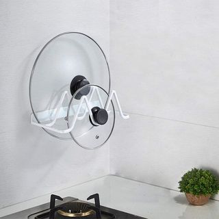 white pan lid holder attached to a wall in a white kitchen