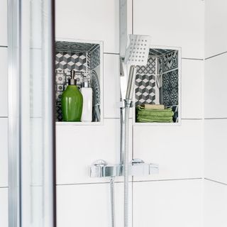bathroom with white tiles on wall shower and towel